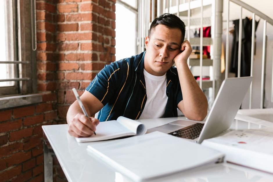 Estudiante distraído mirando el portátil, procrastinando