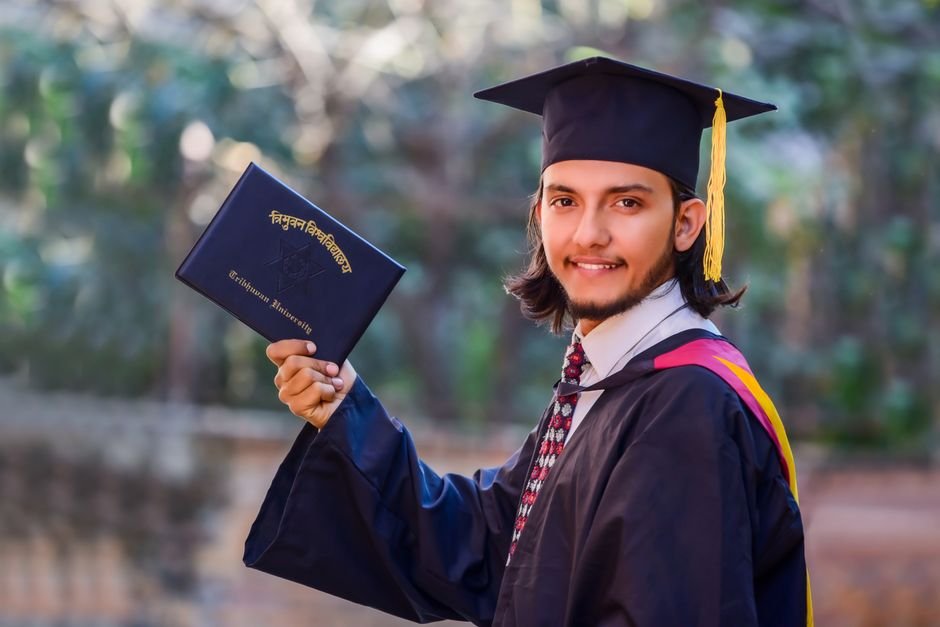 Graduado sonriente con toga y diploma, logro académico