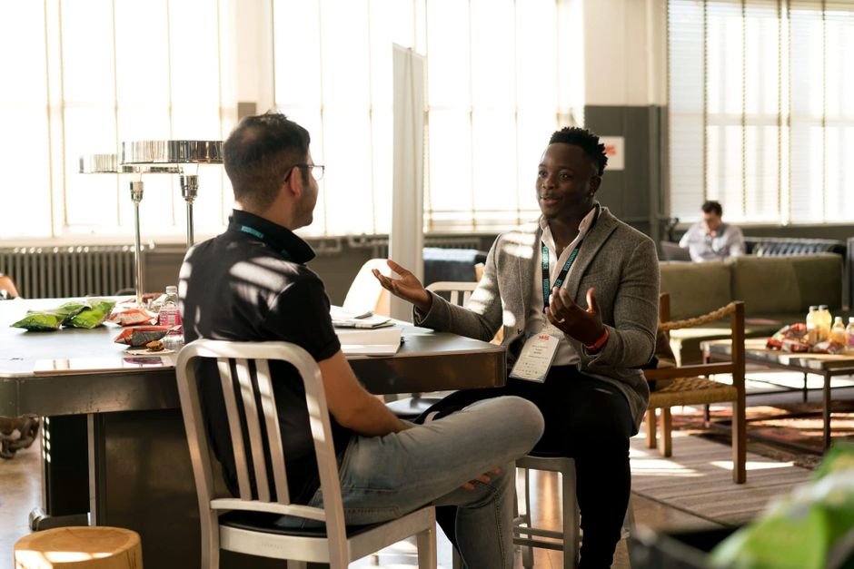 Two professionals having a coaching-style conversation in a bright office setting