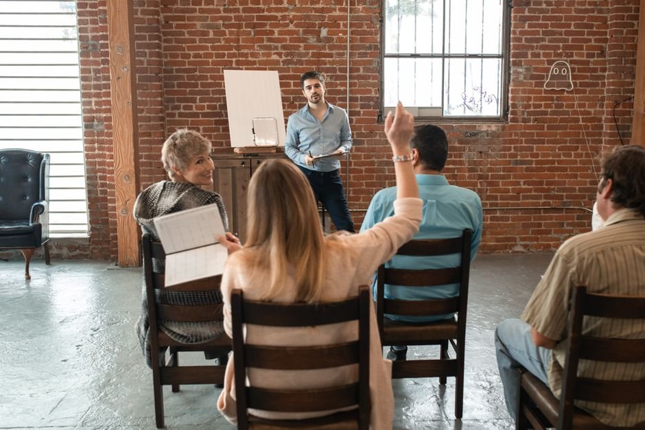 Small group of adults having an informal group coaching discussion in a room