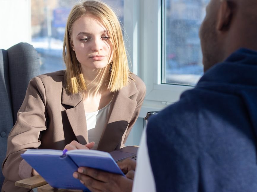A coach and client in a focused one-on-one conversation in a modern office