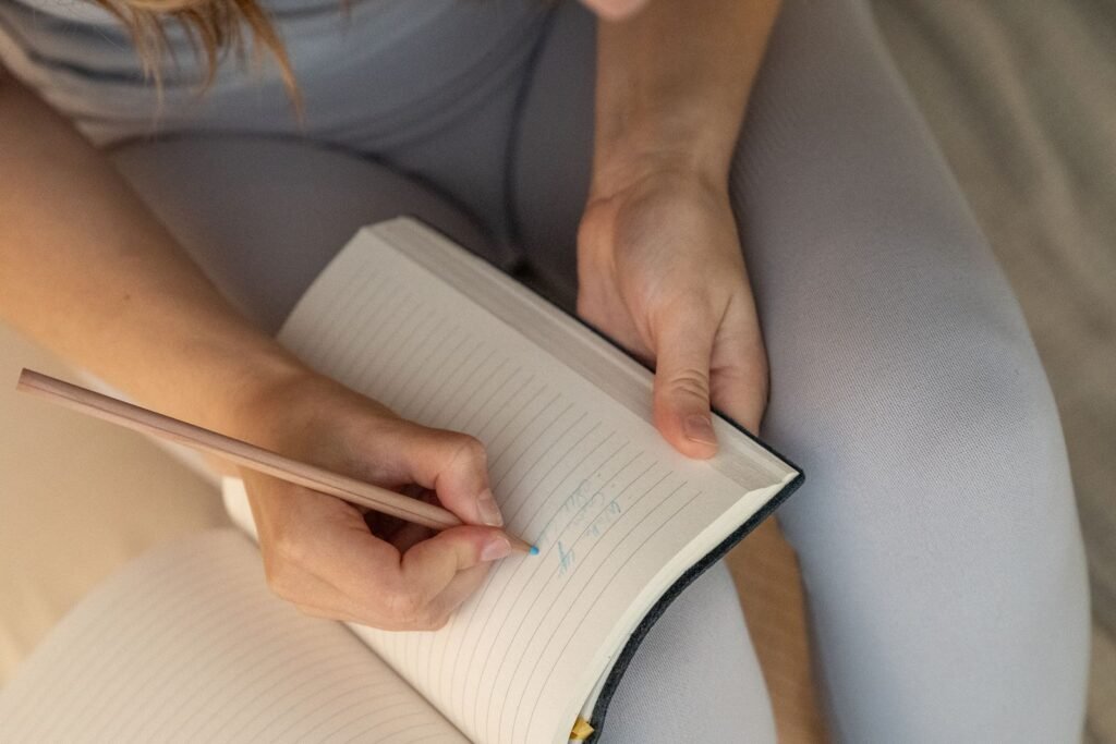 Persona escribiendo en un cuaderno con un lápiz, haciendo el ejercicio de reflexión del ikigai